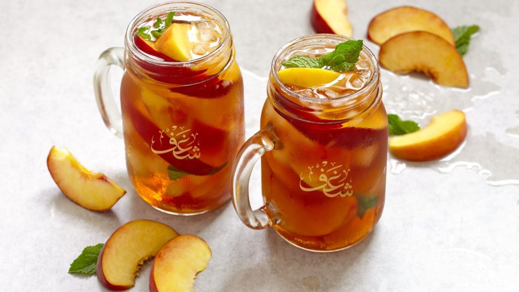 Refreshing glass of Best Peach Tea near Arlington VA at Shaghf Café Falls ChurchVA made with real peach flavor, premium tea leaves, and ice for a perfect summer drink.